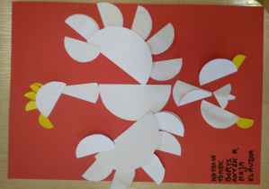 Praca plastyczna. Na dużym czerwonym kartonie orzeł wykonany z różnej wielkości białych kółek z origami.